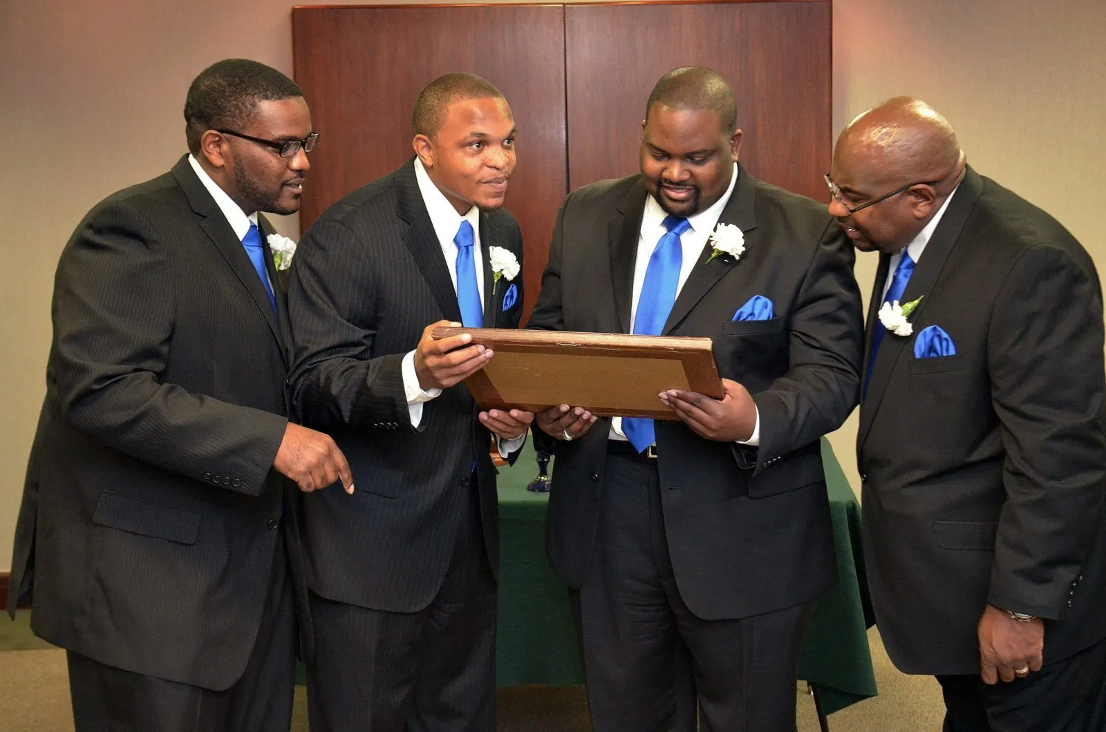Brothers presenting a commemorative plaque